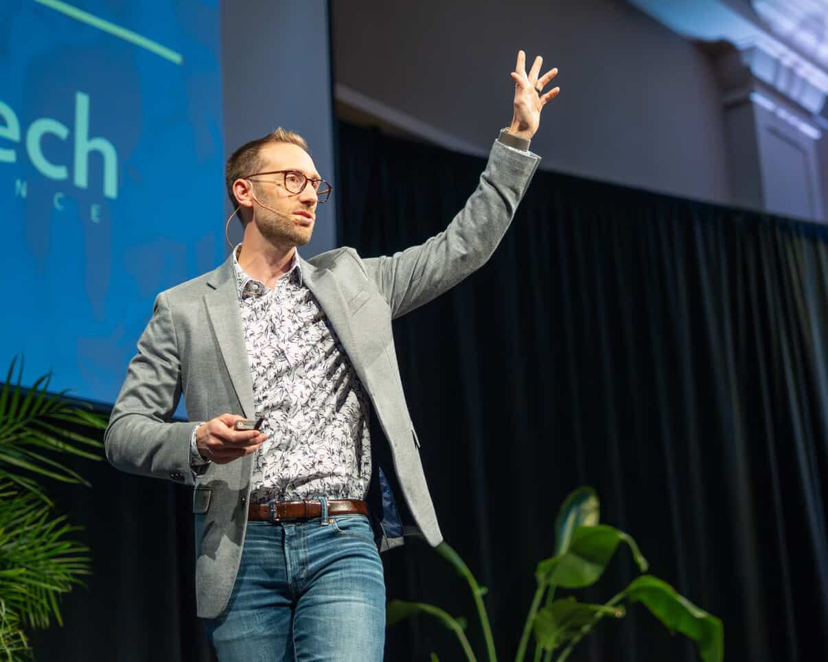 John Charette teaching on stage, one arm raised mid-explanation